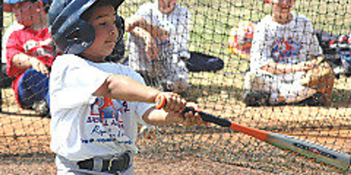 Kid hitting baseball in helmet