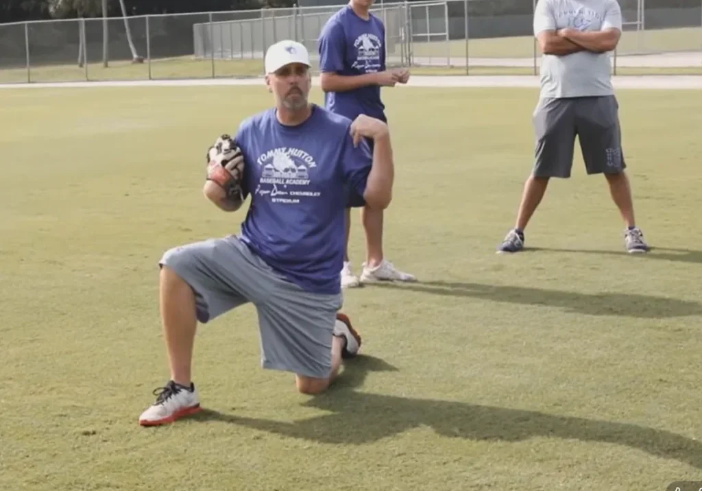 Coach kneeling during baseball training