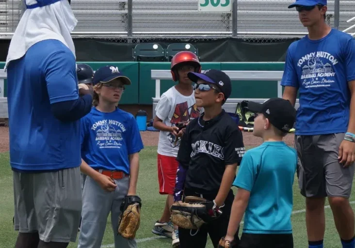 Youth baseball team huddled with coach